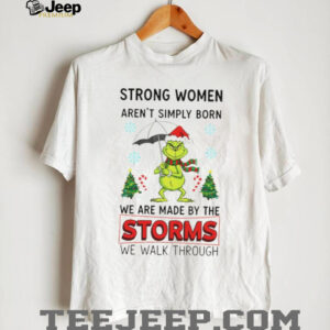 Grinch Santa hat strong women aren’t simply born we are made by the storms we walk through Merry Christmas shirt
